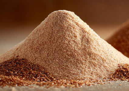 Flaxseed pile of brown flax seeds on a wooden surface with a blurred background