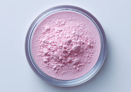 Chromium Pink powder in a clear container on a light gray background