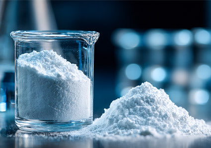 Melatonin White powder in a glass beaker on a reflective surface with a blurred background
